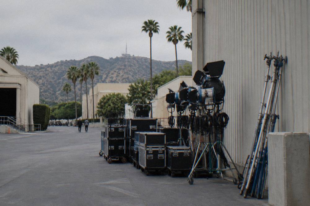 Production equipment and lighting rigs staged beside a soundstage wall