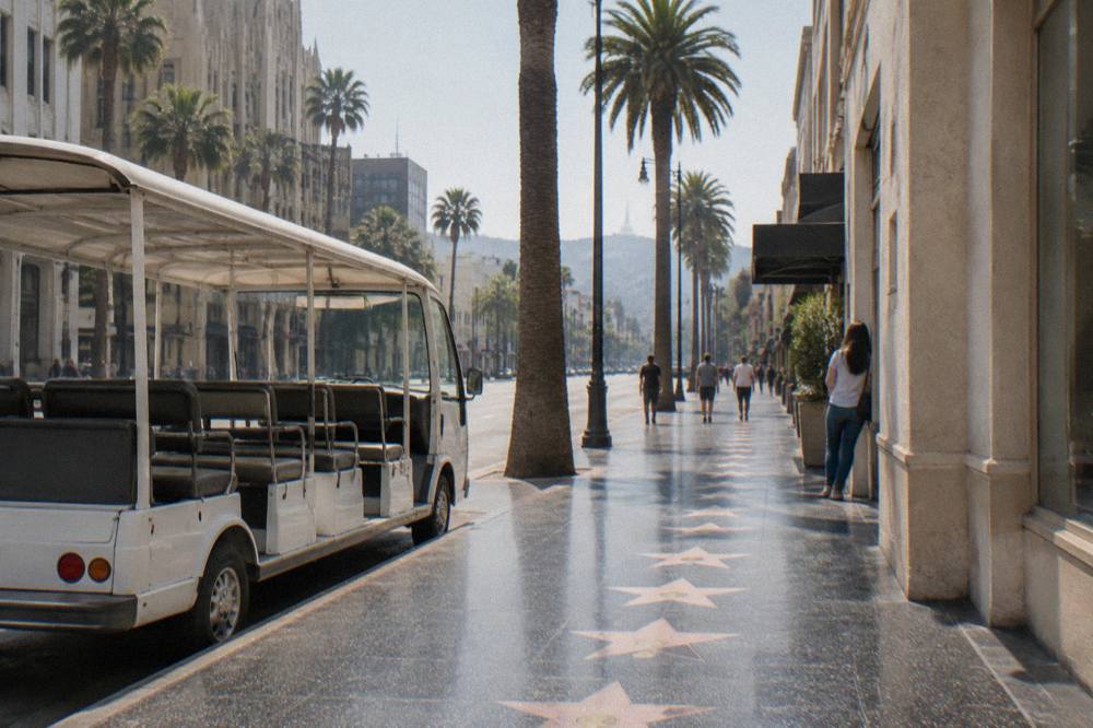 An open-air tour van on a palm-lined Beverly Hills boulevard