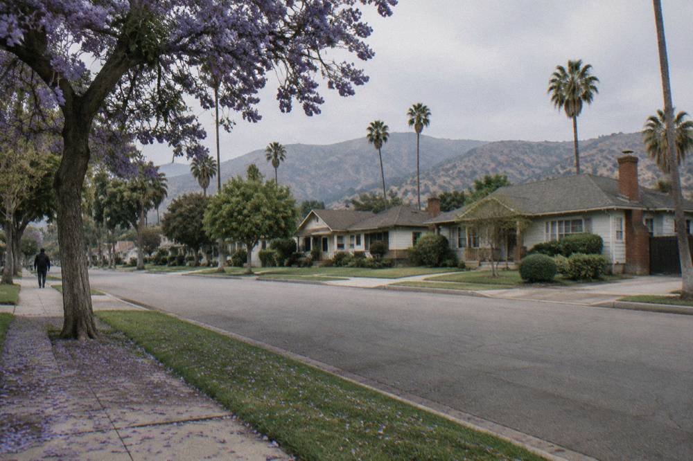 Sunlit residential street in Burbank with low buildings and hills in the distance