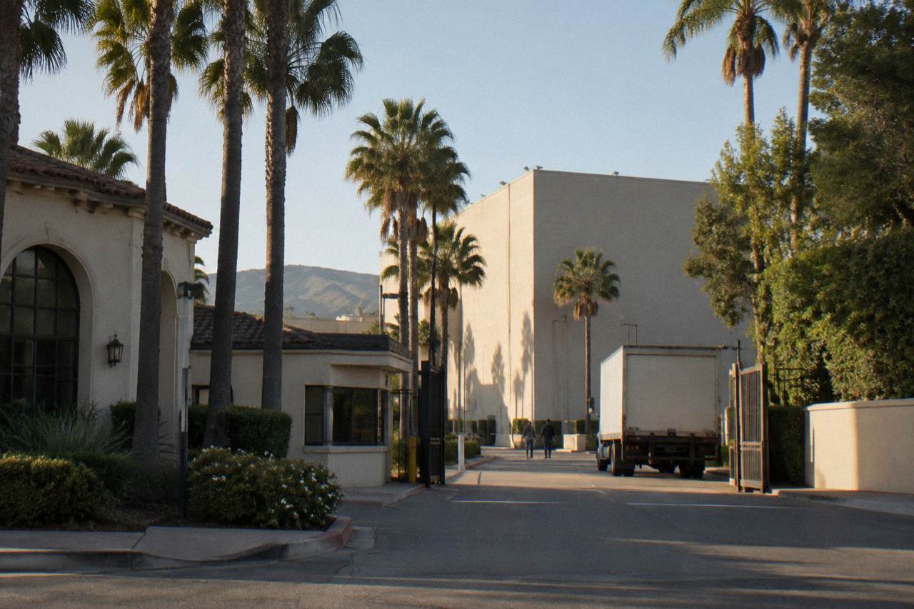 Culver City studio lot entrance with palm trees and a soundstage wall in afternoon light