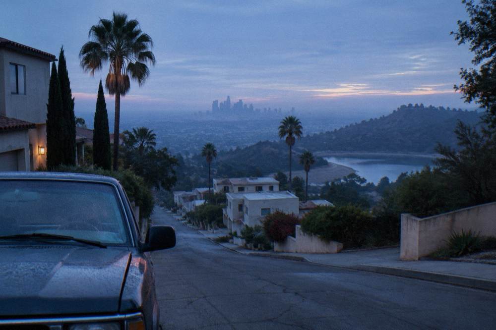 Empty city street in the Hollywood Hills with the Los Angeles skyline in the distance