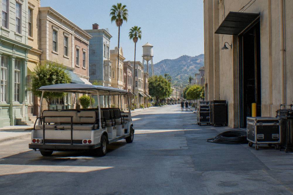 A guided tour cart parked on a Paramount soundstage street beside painted facade buildings