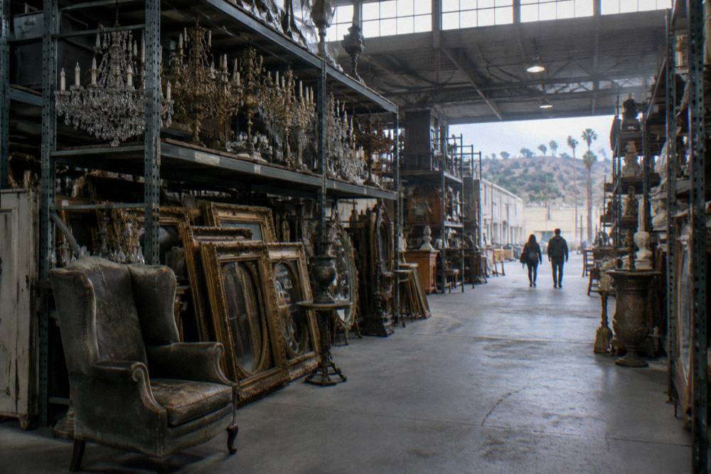Rows of shelved film props inside a studio prop warehouse