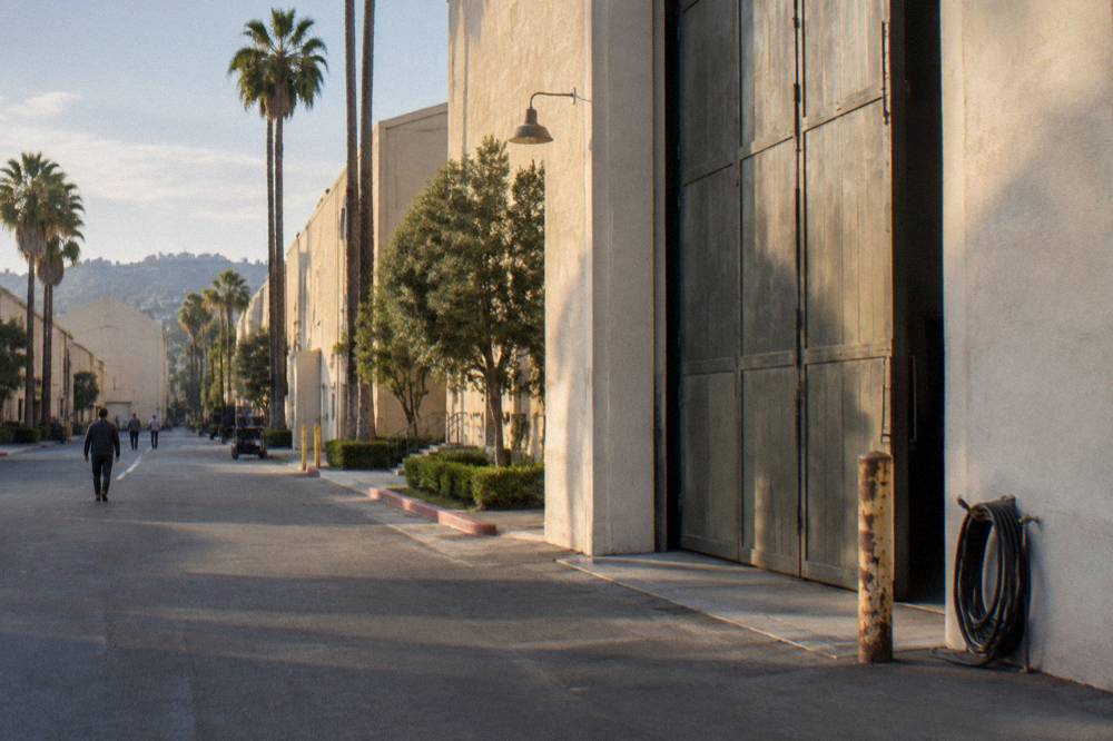 A historic studio soundstage facade with tall doors and warm afternoon light