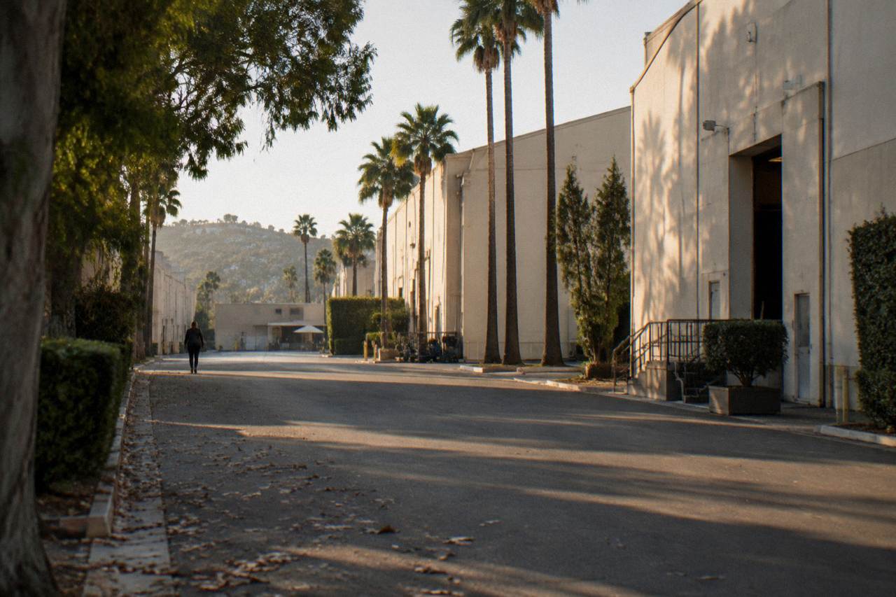 A quiet Culver City studio lot street with soundstage walls and palm trees