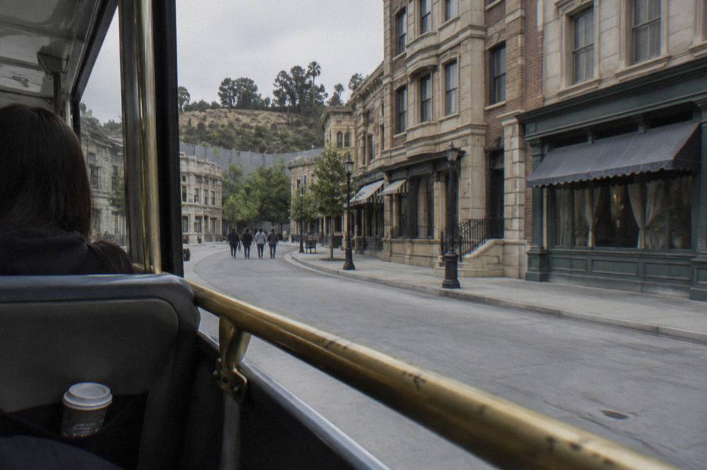 Open-air studio tour tram travelling along a backlot street lined with painted facades