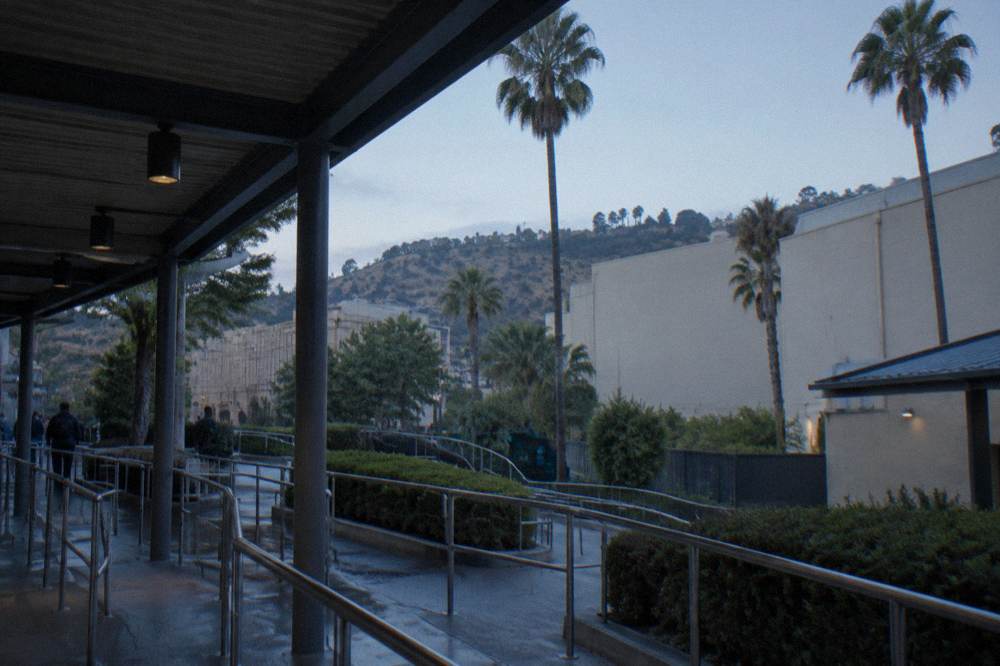 Tram queue structure beside the park entrance with hills and soundstage walls behind it
