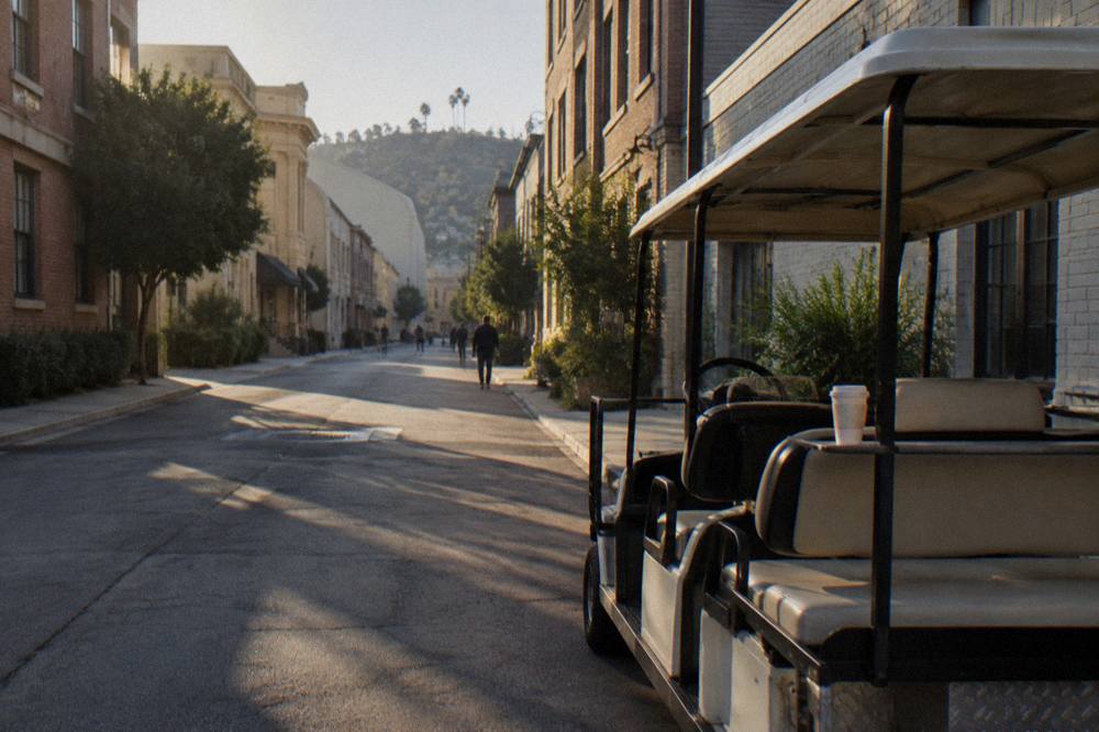 Guided tour cart parked on a studio backlot street with facades on both sides
