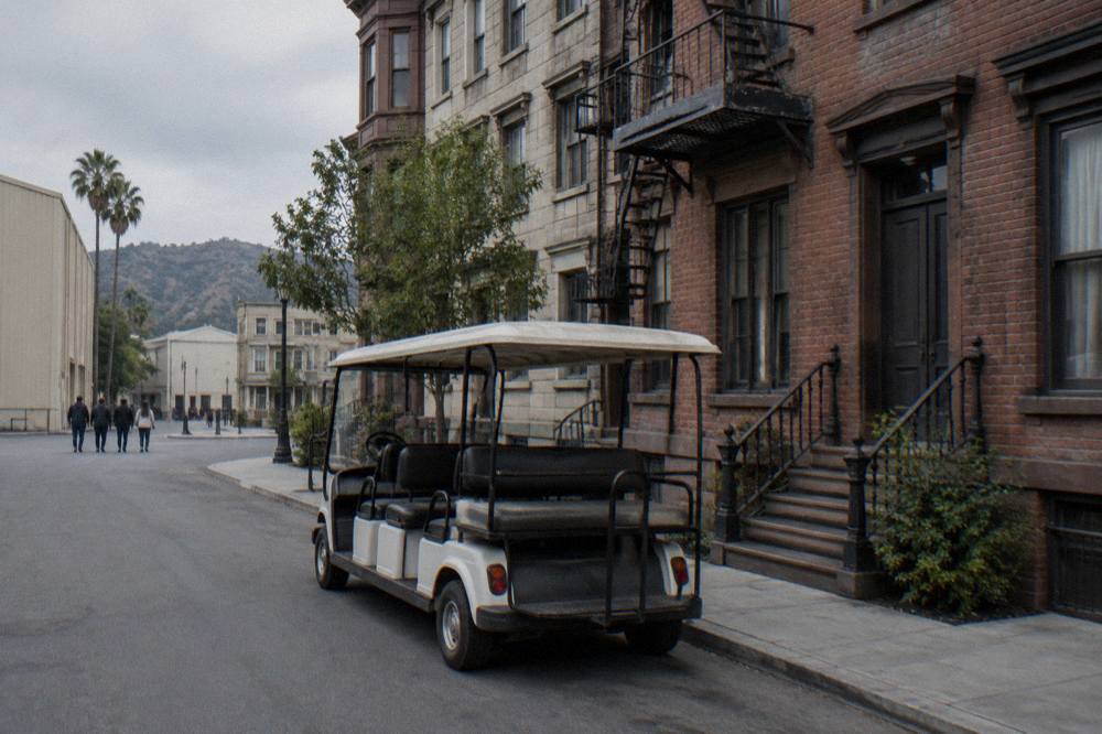 Guided tour cart parked beside a brownstone street set on a studio backlot