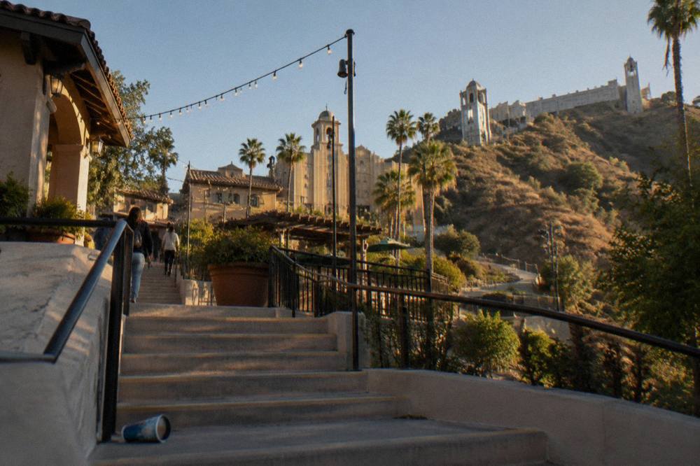 A theme park hillside terraced with stylized facades, decorative lighting and walkways winding between structures