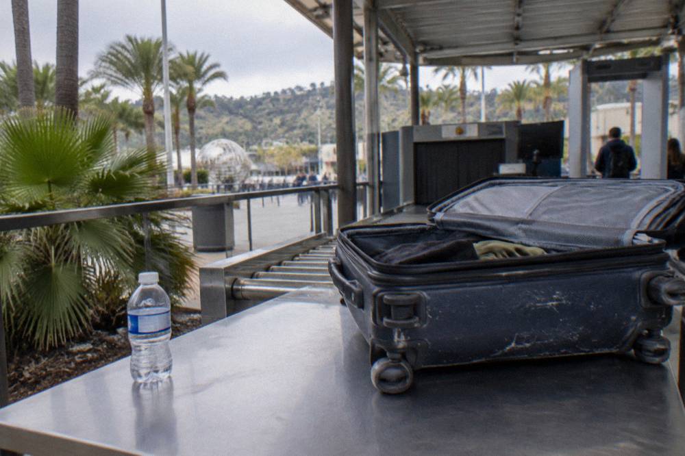 Theme park security screening canopy with bag inspection tables near the entrance