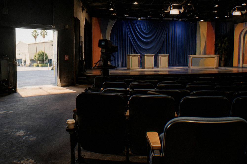Empty audience seating rows facing a covered game show stage