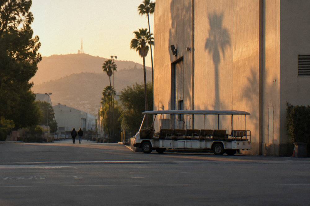 Tour cart parked beside a soundstage building in late afternoon light