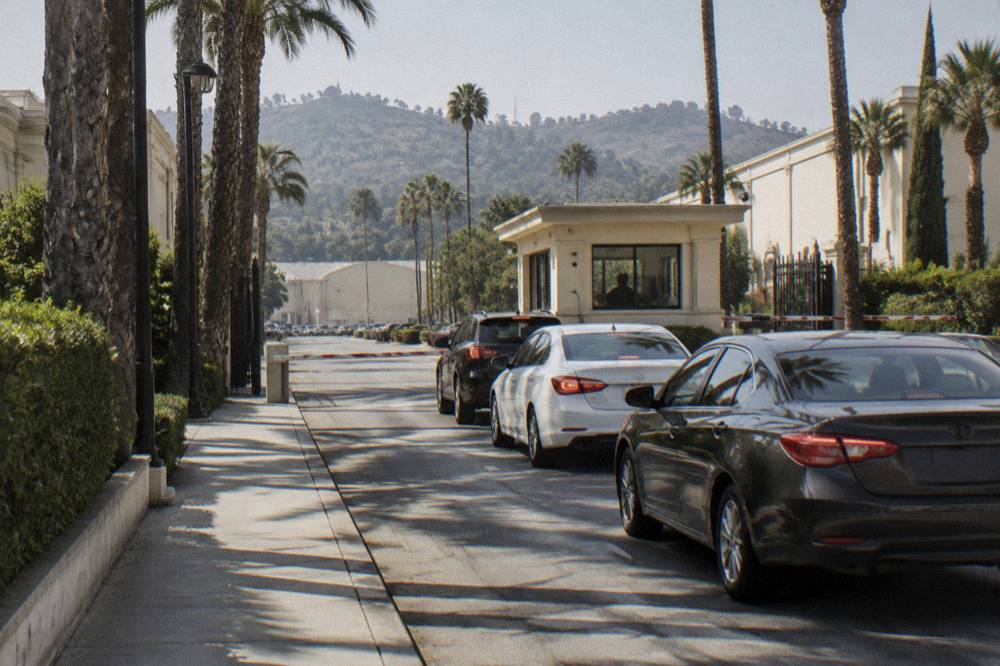 Security gate entrance on Melrose Avenue with vehicles waiting to enter the studio lot
