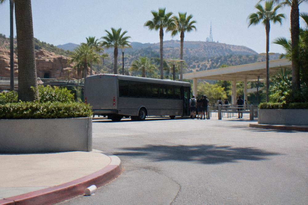 Free shuttle bus loading passengers outside a theme park entrance