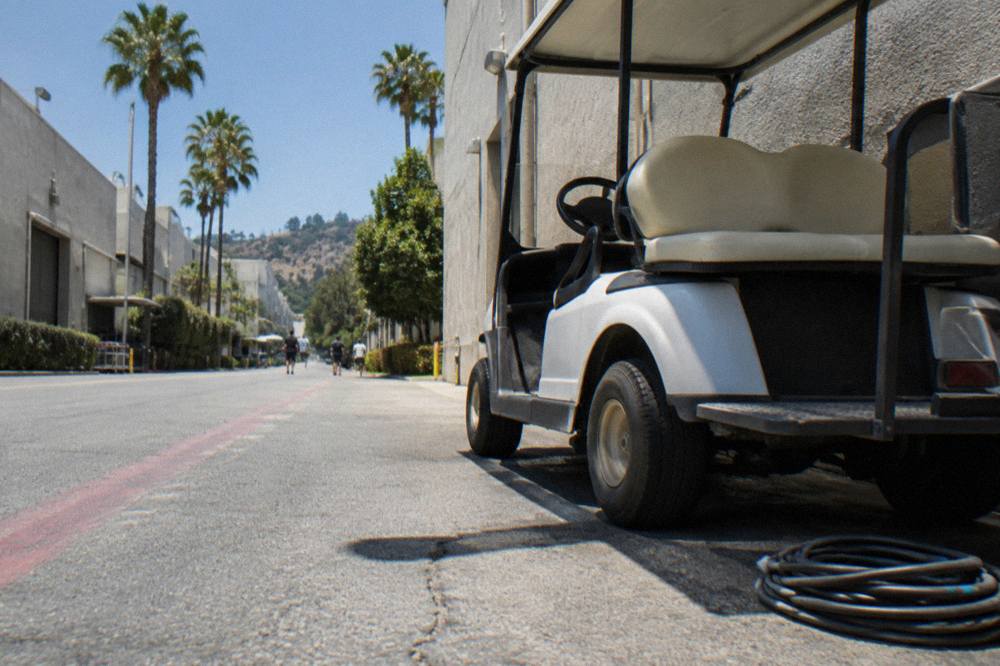 A golf cart tour vehicle parked beside a Paramount soundstage facade