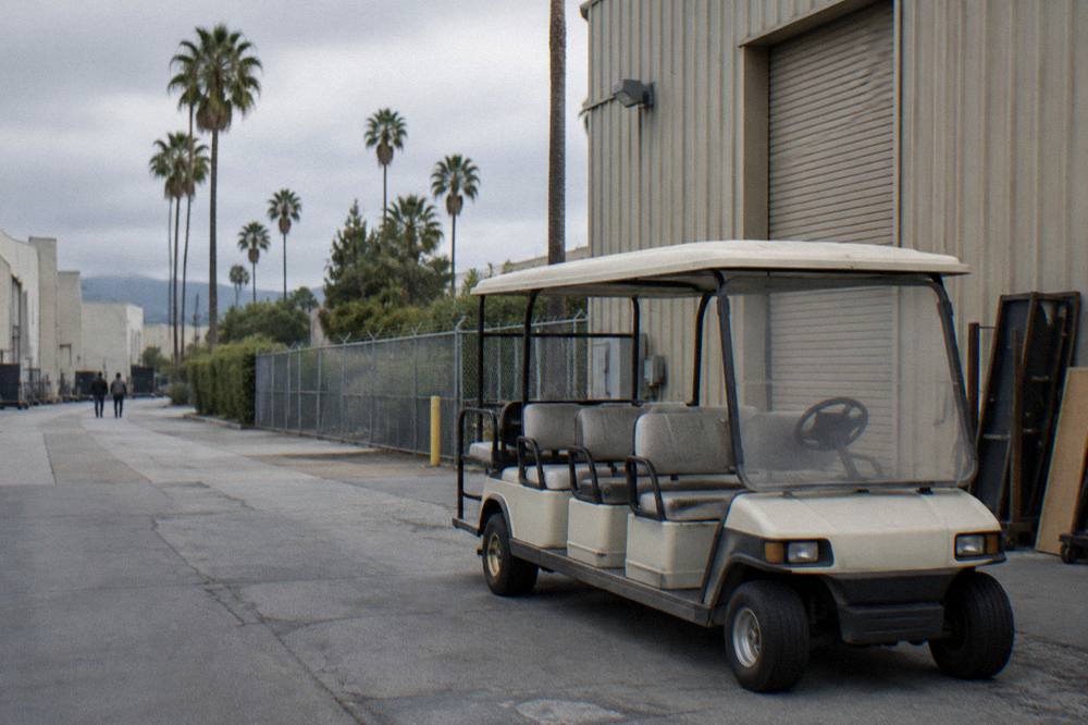 A studio tour cart parked beside a prop warehouse entrance