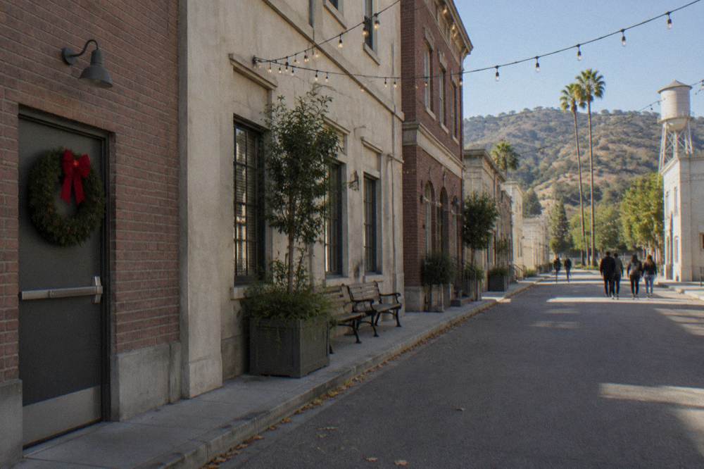 A studio backlot street dressed with holiday decorations and string lights