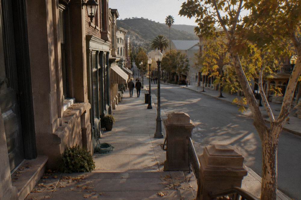 Backlot street set with brownstone facades and vintage storefronts in afternoon light