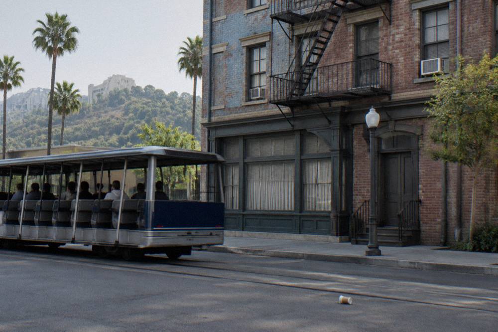 Studio tour tram passing a faux New York street facade on a backlot