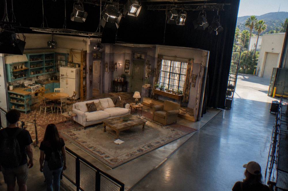 Interior exhibit space with a recreated sitcom set and stage lighting