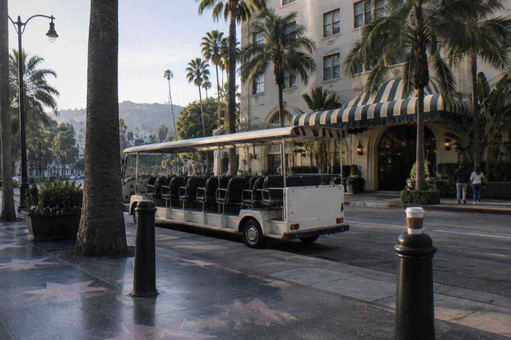 Open-air sightseeing shuttle bus parked on a Hollywood street