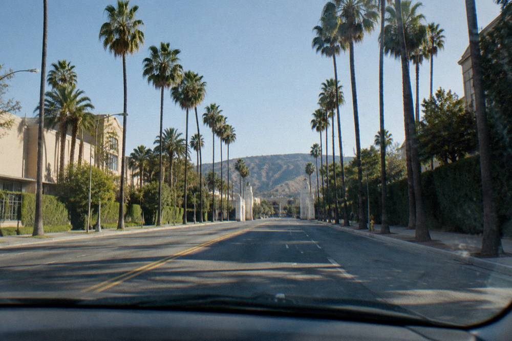Wide view of a Burbank boulevard with cars and studio gates in the distance