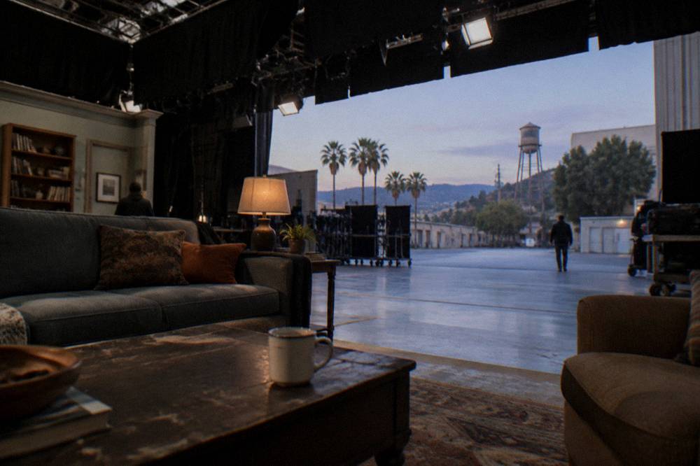 A soundstage interior with lighting rigs above a dressed television set