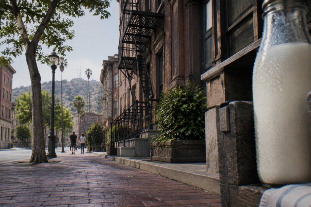 A studio backlot street facade with brownstone storefronts and a period fire escape