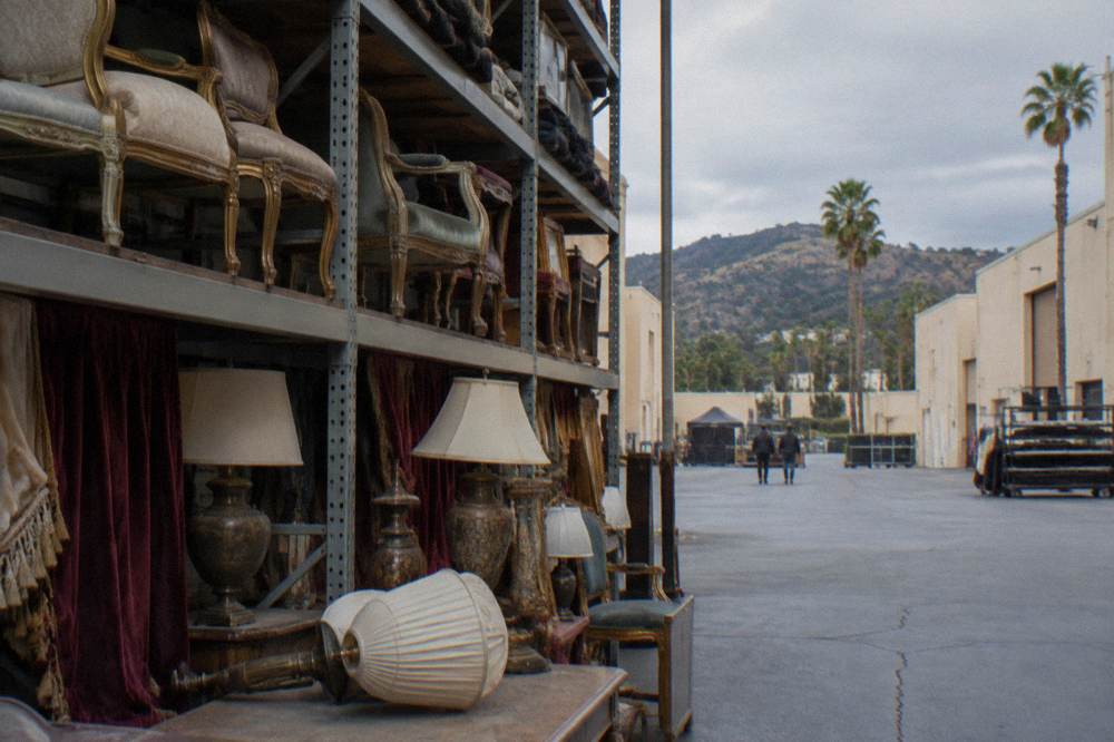 Rows of period furniture and dressings shelved inside a studio property department