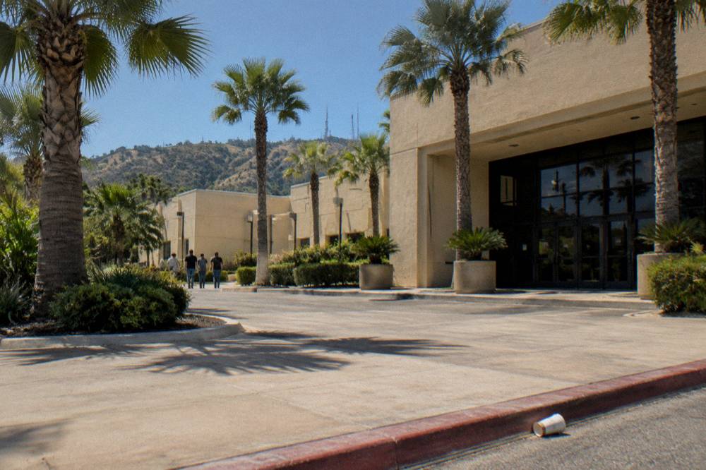 A studio tour welcome center entrance with directional signage under midday sun
